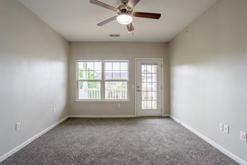 Room with a ceiling fan and two windows.